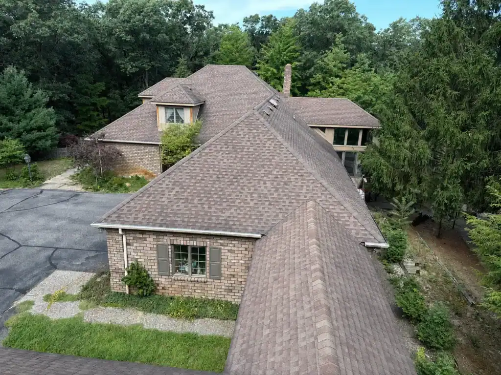 Aerial view of brick house with shingled roof