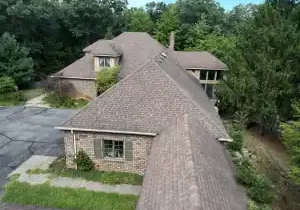 Aerial view of brick house with shingled roof