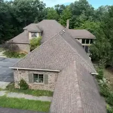 Aerial view of brick house with shingled roof
